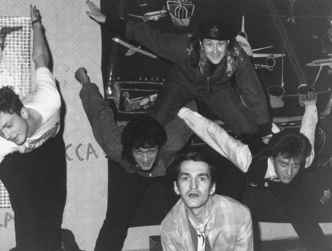 Слева направо: Андрей Крисанов, Виктор Цой, Тимур Новиков, Джоанна Стингрей, Георгий Гурьянов. Галерея «Асса» в квартире Новикова. Ленинград, 1985.<br> Изображение: собрание семьи Тимура Новикова